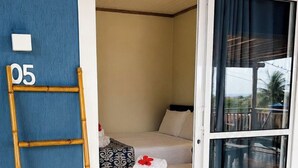 A room with a bed, a ladder, and a sliding door leading to a balcony. - Pousada Alto da Floresta Noronha by Alto da Ilha (Fernando de Noronha)
