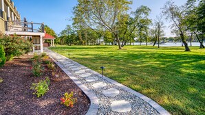 A landscaped garden with a stone pathway, a gazebo, and a lake view. - Island Life!  Kent Island Waterfront with Pool-Bring your boat! (Stevensville)