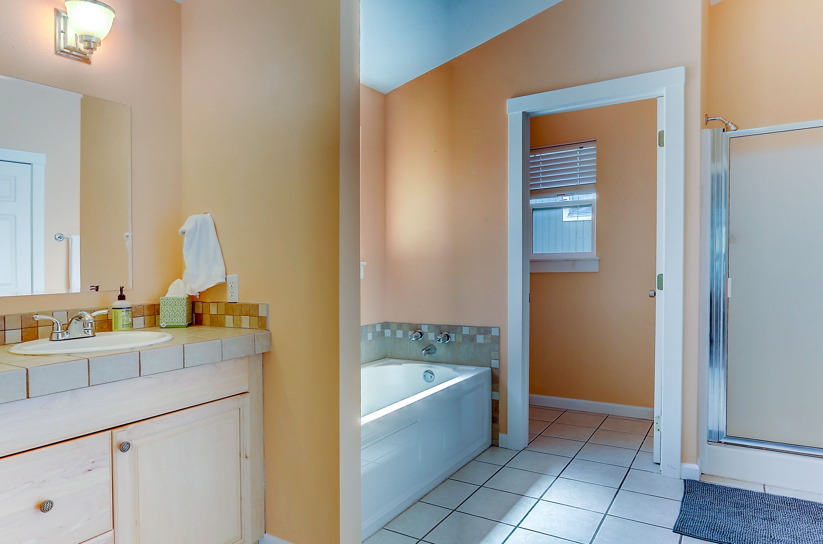 Une salle de bain avec un lavabo, un miroir et une baignoire.