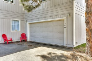 Een garage, twee rode stoelen en een boom.