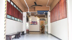 A modern lobby with a ceiling fan, benches, and a colorful abstract painting on the wall. - Comfy accom. 2(BTS Saphan Khwai) (Bangkok)