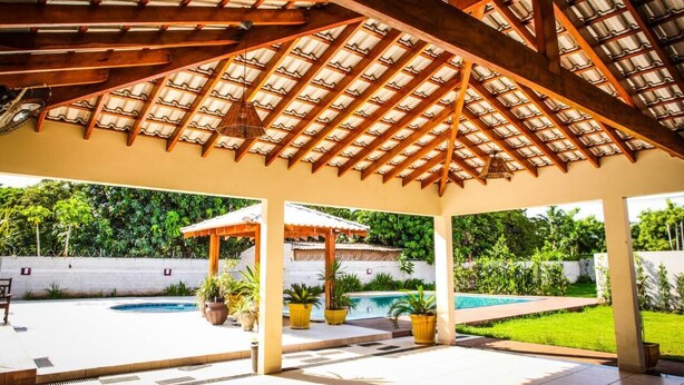 Un espace extérieur abrité comprenant une piscine, des plantes en pot et une structure en forme de pergola.