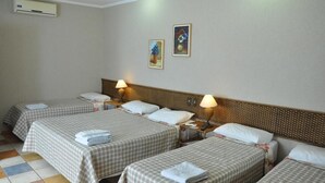 A hotel room with two beds, each with a checkered bedspread and pillows, a nightstand with a lamp, and a wall-mounted air conditioner. - Pousada Beco da Lua (Olímpia)