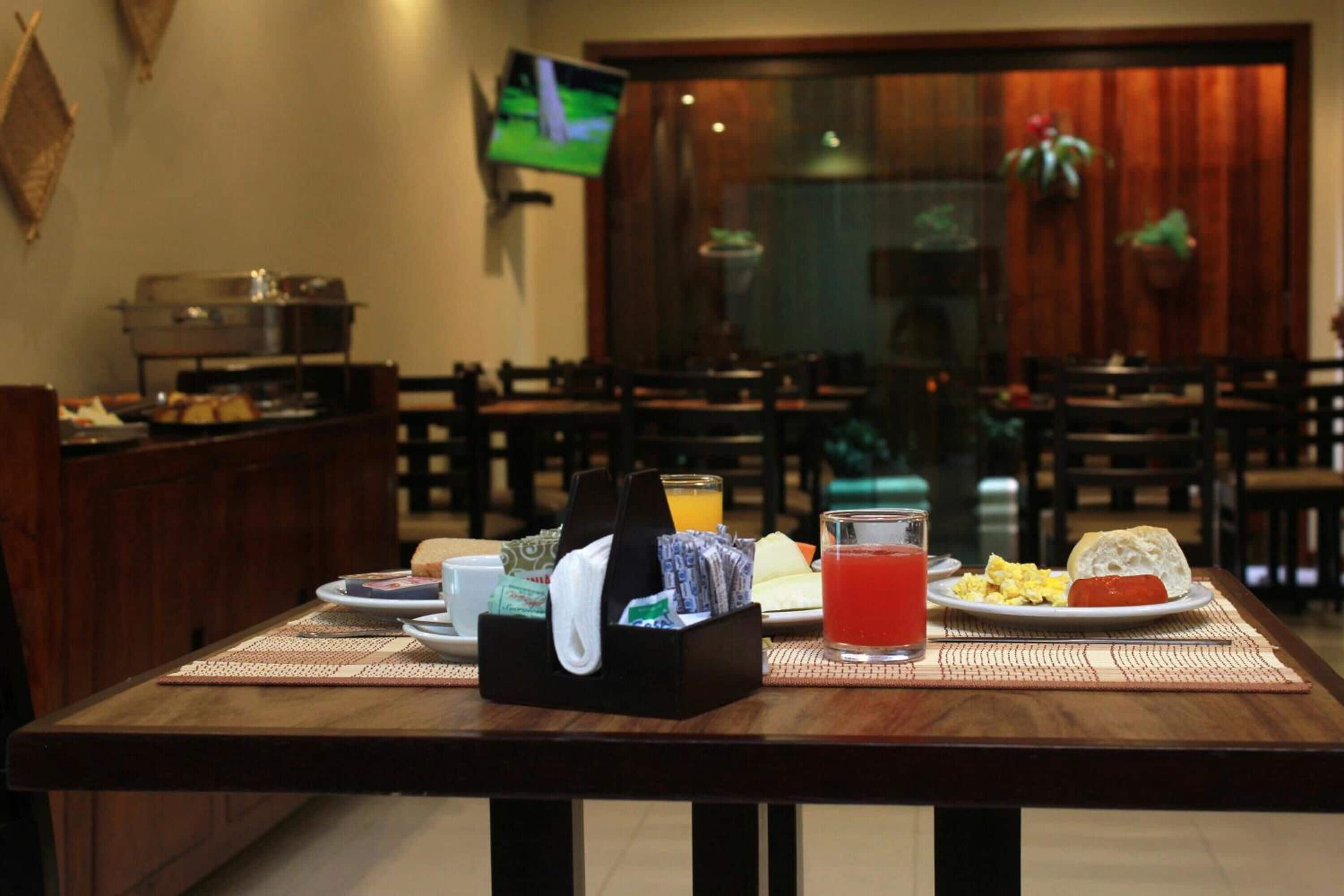 A dining area with a buffet setup, including a variety of food items and beverages on a table.