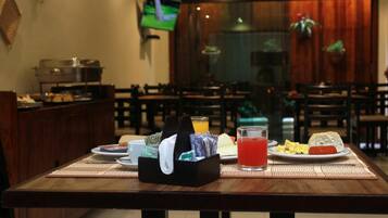 A dining area with a buffet setup, including a variety of food items and beverages on a table.