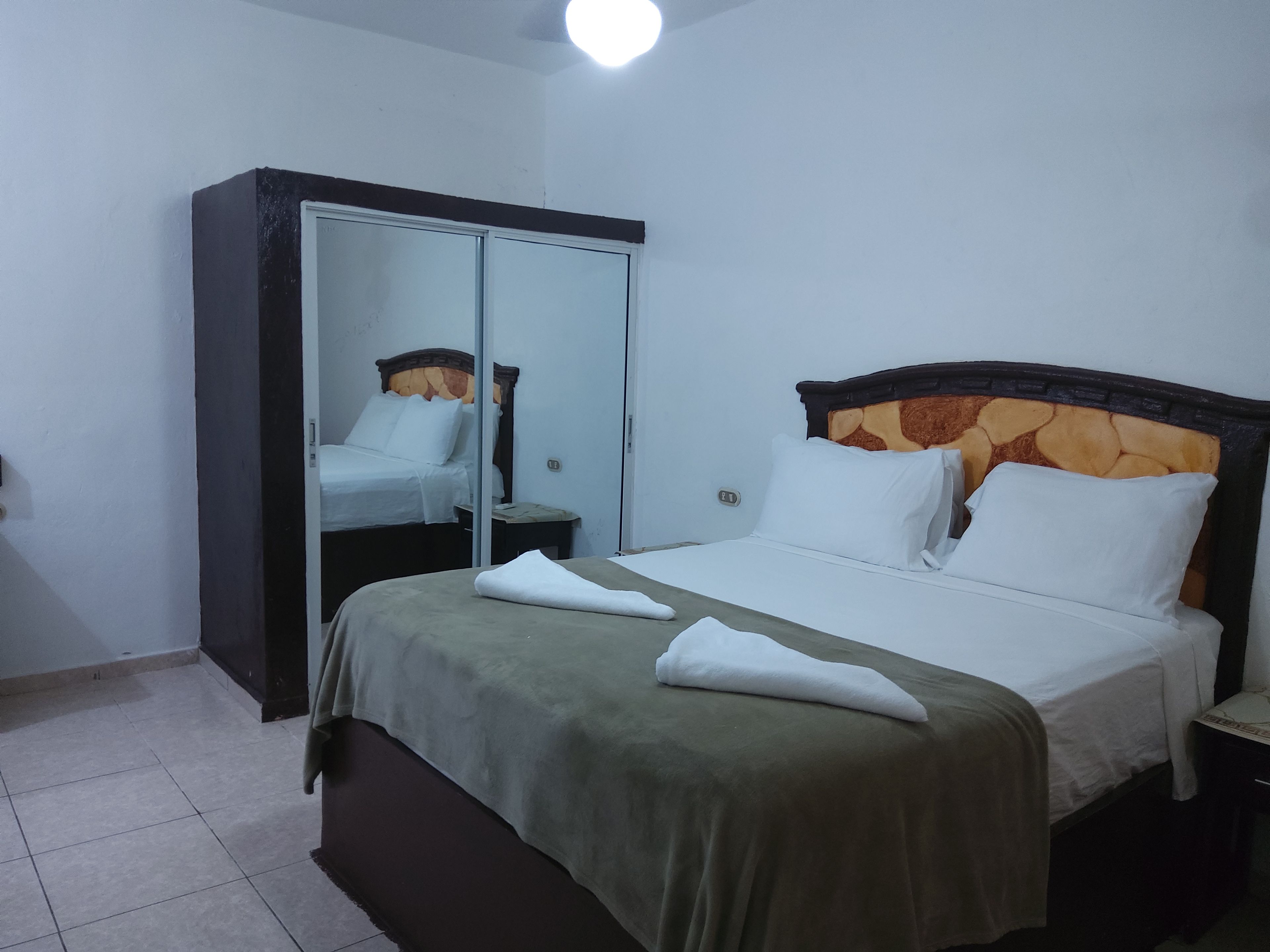 Een hotelkamer met een bed, een kast en een spiegel.