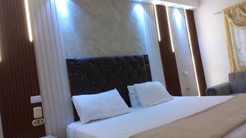 Ein Hotelzimmer mit einem großen Bett, einem Nachttisch und einem Sessel.