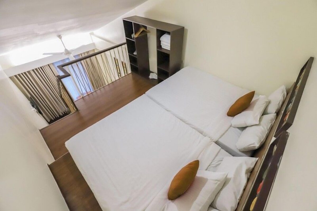 A hotel room with two beds, a wardrobe, and a balcony with curtains.