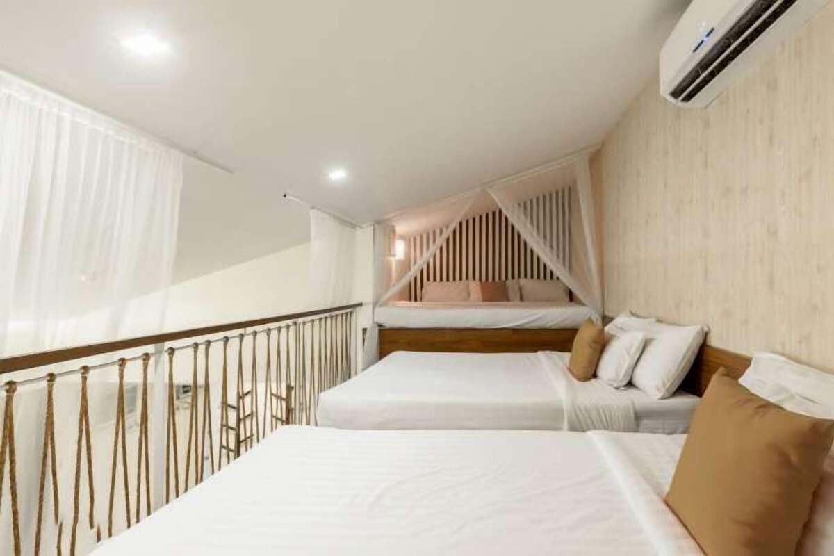 A hotel room with two beds, a balcony, and an air conditioning unit.