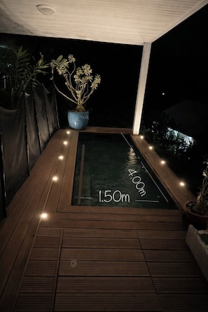 A wooden deck with a glass-bottomed hot tub, surrounded by potted plants and a dark night sky. - Relaxing stay with whirlpool at Sarabi House (Residence Nakiya) (Sainte-Marie)