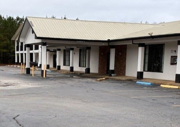 A building with a flat roof, multiple windows, and a parking lot.