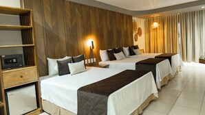 A hotel room with two beds, a wooden panel wall, a minibar, and a large window with curtains.