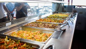 A buffet with various dishes, including salads, meats, and vegetables.