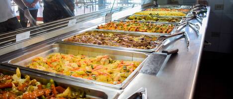 A buffet with various dishes, including salads, meats, and vegetables.