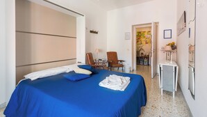 A hotel room with a bed, a chair, a small table, and a lamp. - Large apartment with Wi-Fi and terrace (Roma)