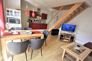 Cozy living space with a dining area, television, and kitchen, perfect for relaxation and casual gatherings.