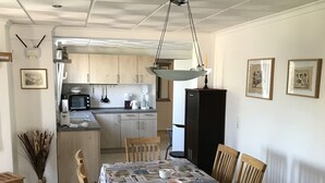 Ein Essbereich mit Tisch für vier Personen, Holzkästen und einer Tischdecke mit Muster.