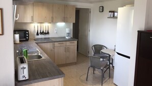 Eine kleine Küche mit Holdekor, eingebautem Toaster, Kaffeemaschine und Kühlschrank.