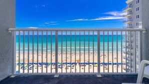Un balcon avec vue sur une plage et l’océan.