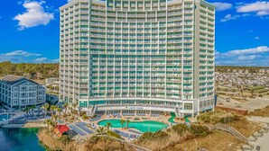 Un hôtel à plusieurs étages doté d’une piscine et entouré d’un paysage côtier.