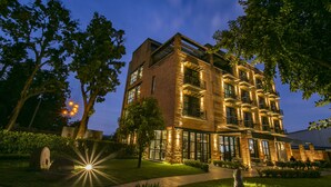 Un edificio de varios pisos con fachada de ladrillo, amplias ventanas y zonas de estar al aire libre.