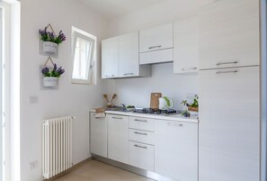 Enjoy cooking in this well-equipped kitchen with a gas stove, window, and radiator.