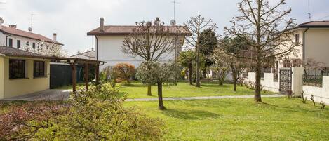 A residential area with houses, a grassy lawn, and trees.