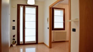 A hallway with a wooden door, a radiator, and a light fixture. - Your home near Venice - Free Parking (Venezia)