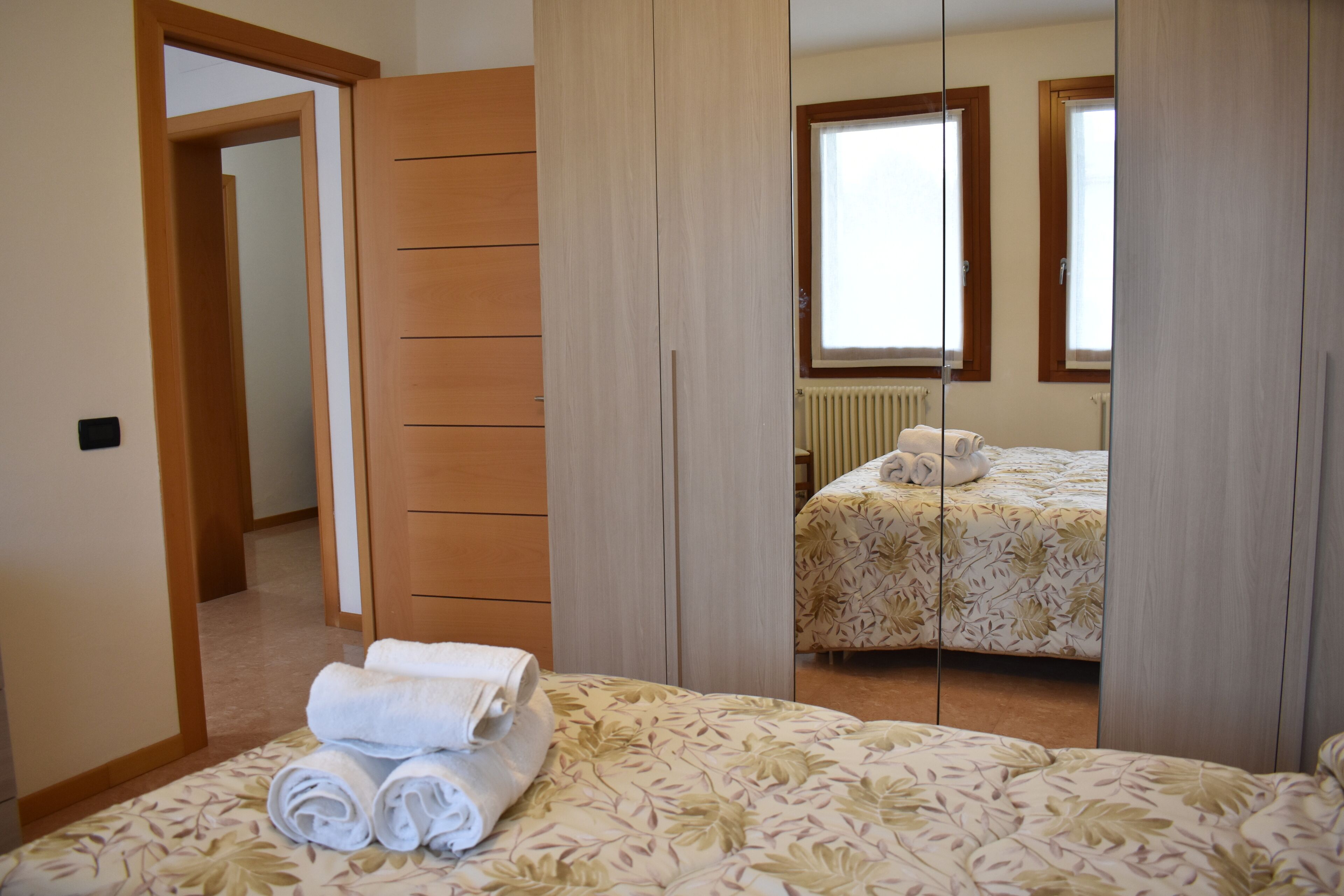 A bedroom with a bed, a wardrobe, and a window.