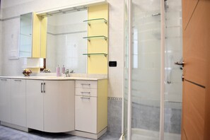 A bathroom with a white vanity, a large mirror, and a glass shower enclosure. - Your home near Venice - Free Parking (Venezia)