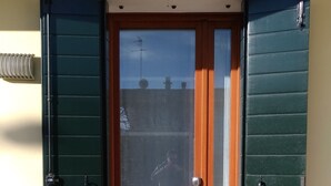 A front door with green shutters, a glass panel, and a wooden door. - Your home near Venice - Free Parking (Venezia)