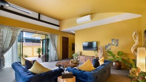 Una sala de estar moderna con un sofá azul, una mesa de centro de madera y plantas en macetas.