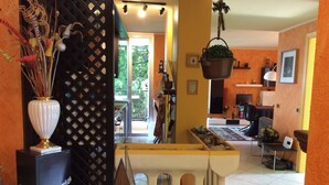 A living room with a sofa, a coffee table, and a TV. There is a window with a view of trees. - EVASION AU FIL DE L'EAU.... (CIN IT003062C24G5JPZGD) (DORMELLETTO)
