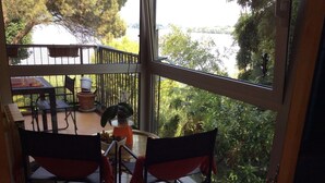 A balcony with two chairs, a table, and a potted plant. - EVASION AU FIL DE L'EAU.... (CIN IT003062C24G5JPZGD) (DORMELLETTO)