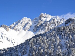 A snow-covered mountain landscape with rocky peaks and dense forests. - 10m from ski slopes, 3rd floor, balcony, 40m², Méribel-Mottaret (Méribel - Les Allues)