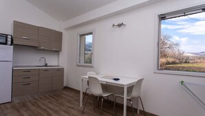 Cozinha moderna com área de jantar, janela com vista e micro-ondas embutido.