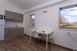 A modern kitchen with a dining area, a window with a view, and a built-in microwave.