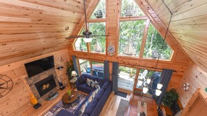Ett rymligt rum i loftstil med ett stort fönster, en öppen spis, en soffa och en matplats.