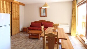 A compact kitchen with wooden furniture, a dining table, and a sofa. - 1st floor, balcony, tv, ski locker, 46m², Aussois (Aussois)