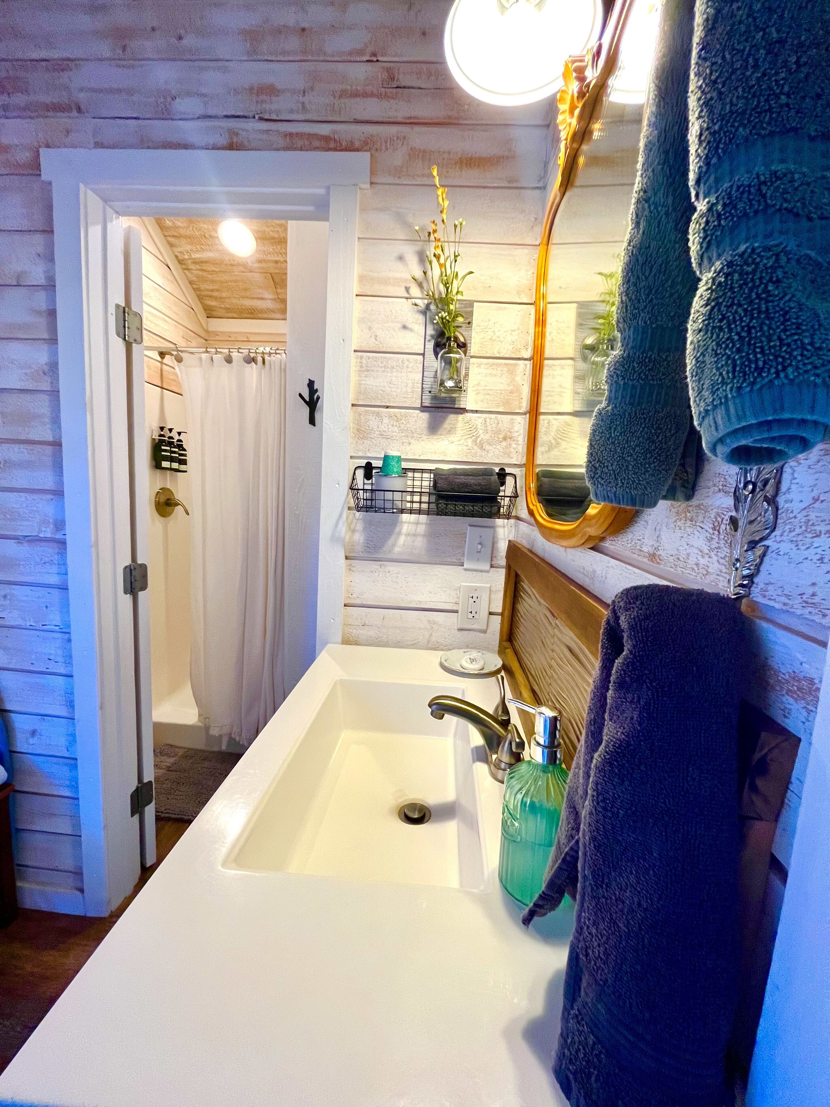 A bathroom with a white sink, a mirror, and a towel rack.