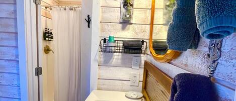 A bathroom with a white sink, a mirror, and a towel rack.