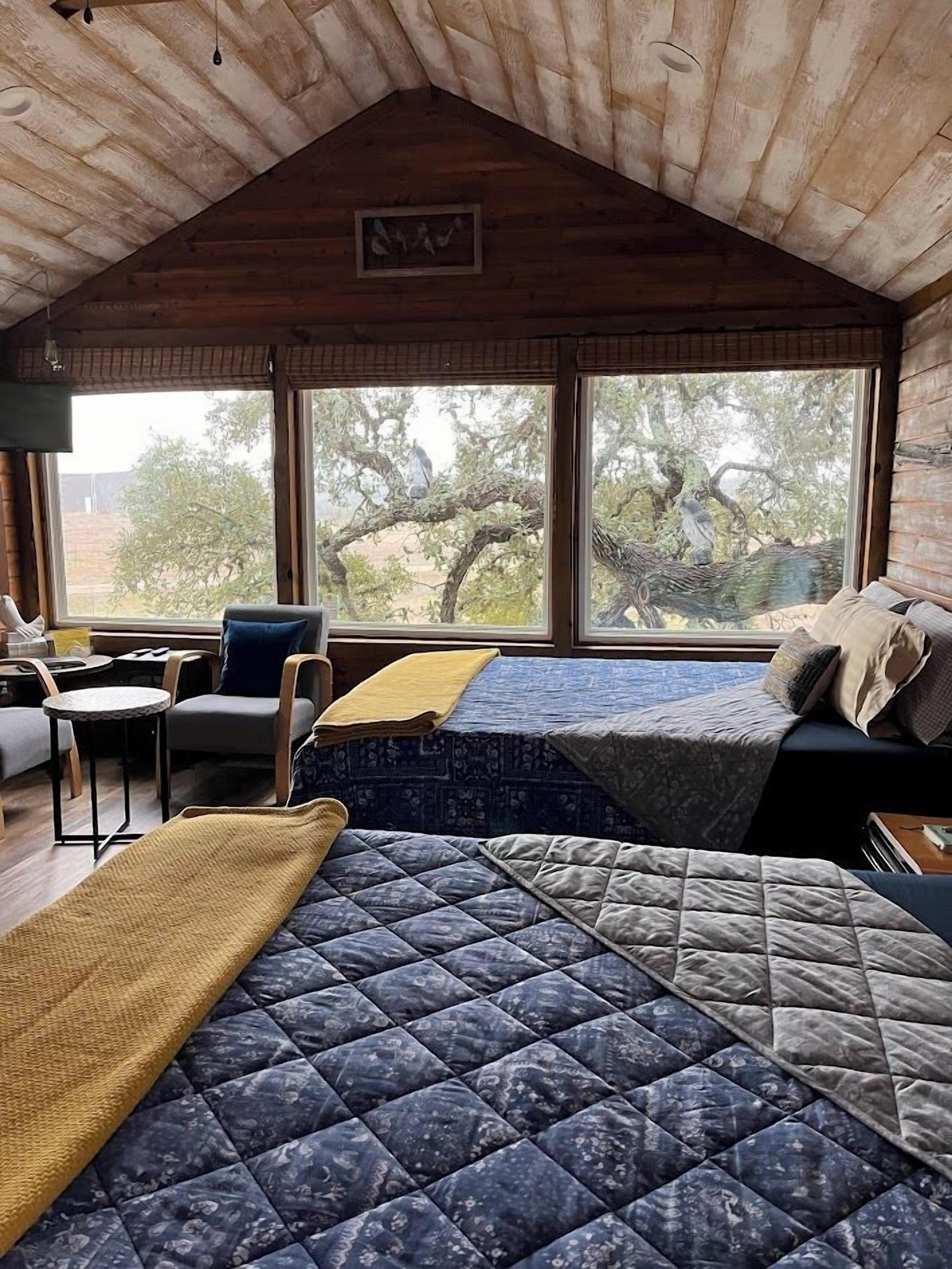 Interior acogedor de una cabaña con una cama en altillo, una mesita y una silla.