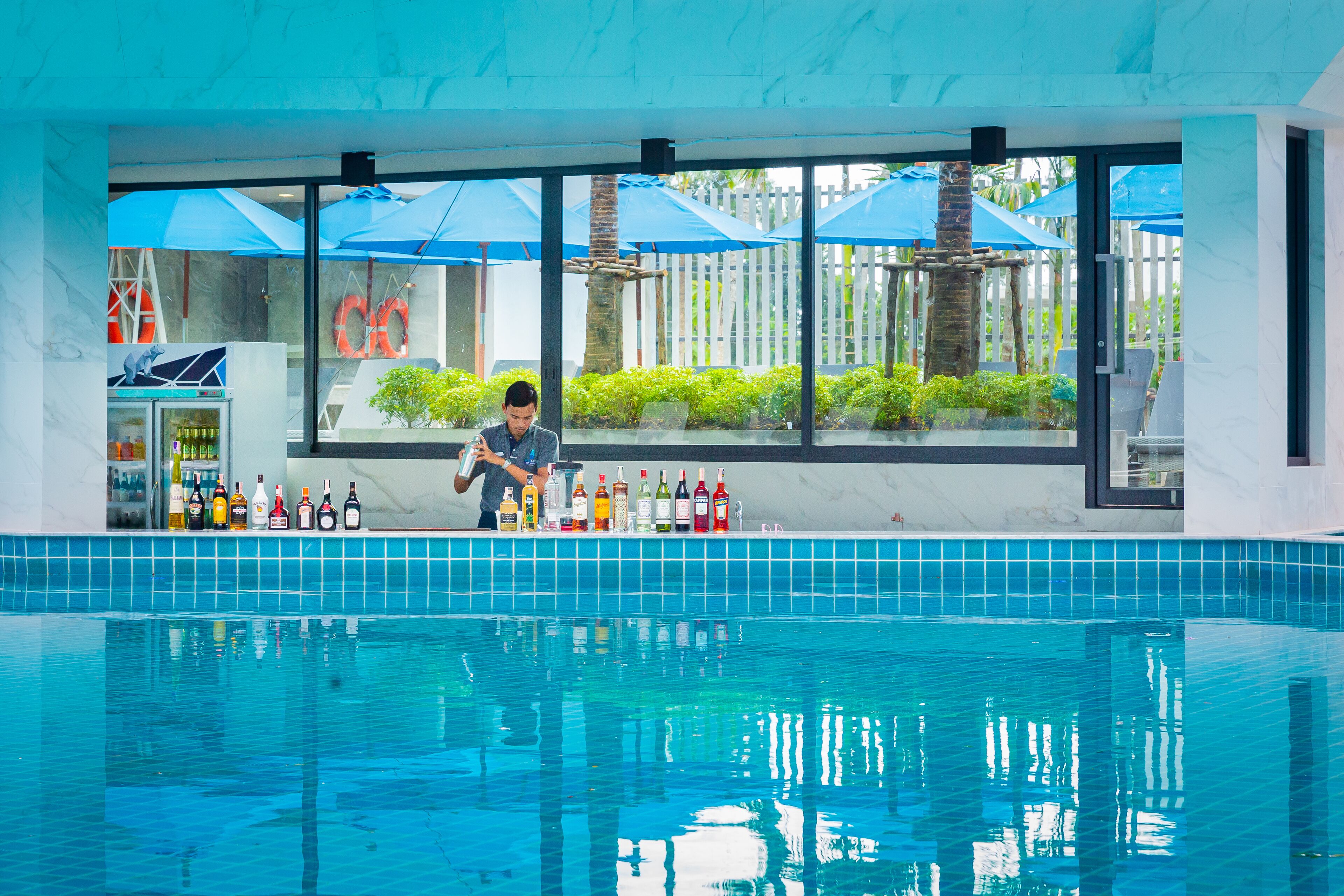 A bar area with a pool in the background.