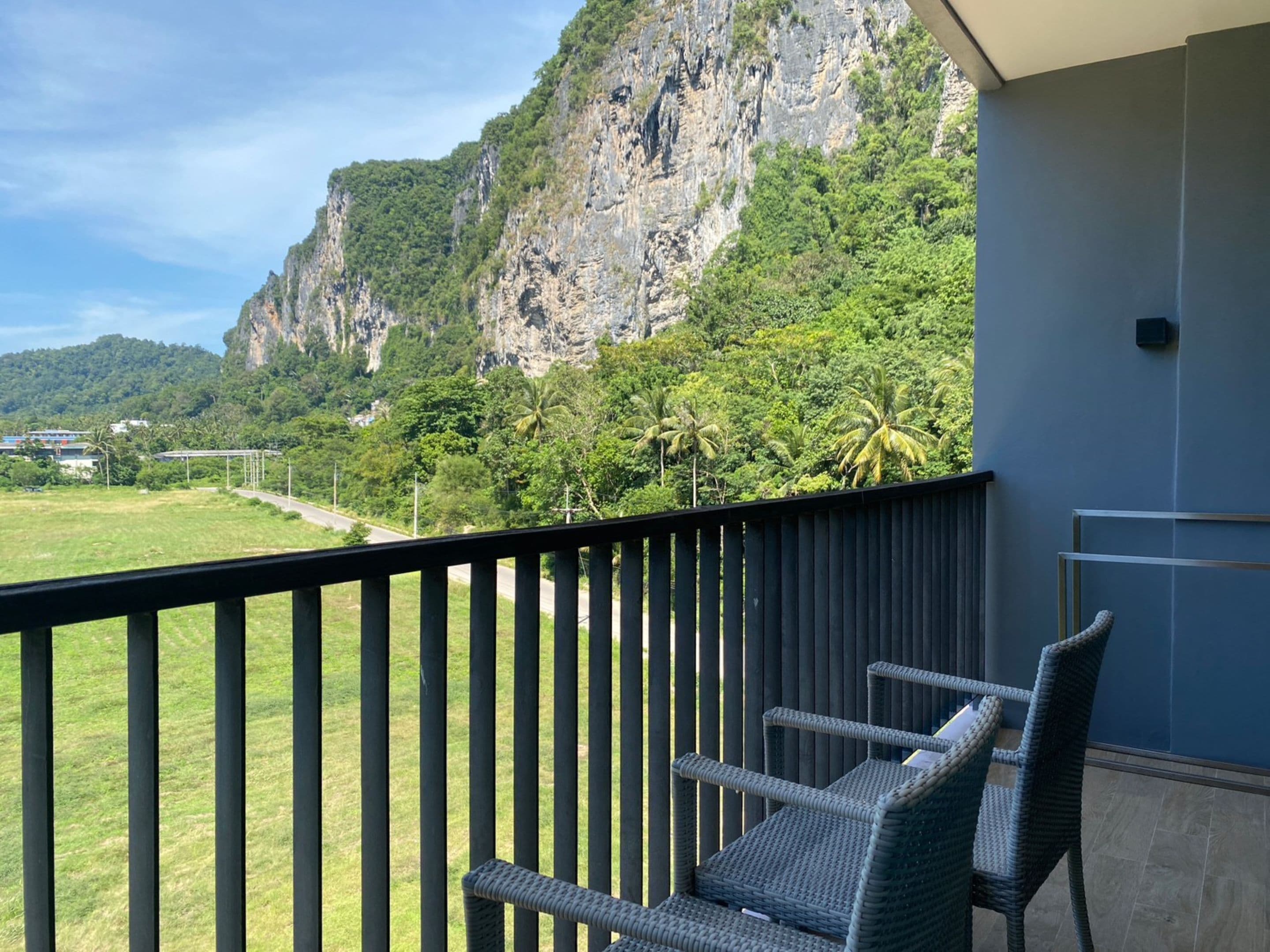 A balcony with a view of a mountainous landscape and a road.