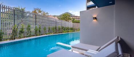 A poolside area with lounge chairs and a clear view of the pool.