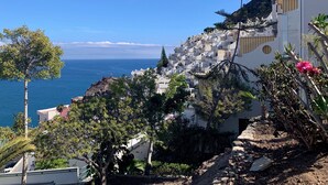 A coastal town with white buildings, a rocky cliff, and a view of the sea. - Ocean view apartment in Playa del Cura Gran Canaria (Mogán)