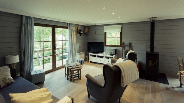 Un salón amplio con un gran ventanal, chimenea, televisor y una zona de estar acogedora.
