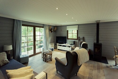 Scandinavian chalet in lush greenery and forest ...