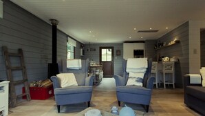 Una sala acogedora con dos sillones azules, una mesa de centro de madera y una chimenea.