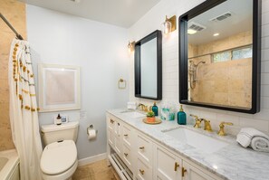 Een bad/douchecombinatie, een bubbelbad, een haardroger, een bidet